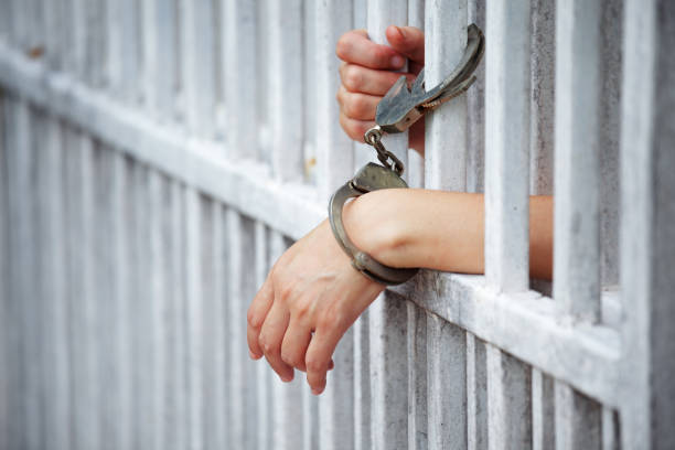 hands of prisoner locked with handcuff in jail